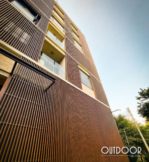 Fachada Residencial en PVC Foliado tipo madera de color Nogal. Revestimiento exterior con tubular de cero mantenimiento para casa moderna en La Castellana.